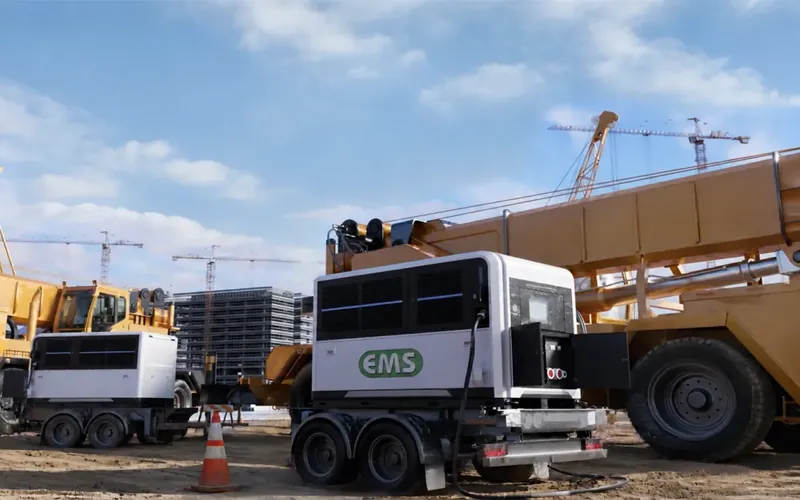 وحدات بطاريات EMS بجوار شاحنة نقل تعدينية وجهاز حفر في أرض مفتوحة